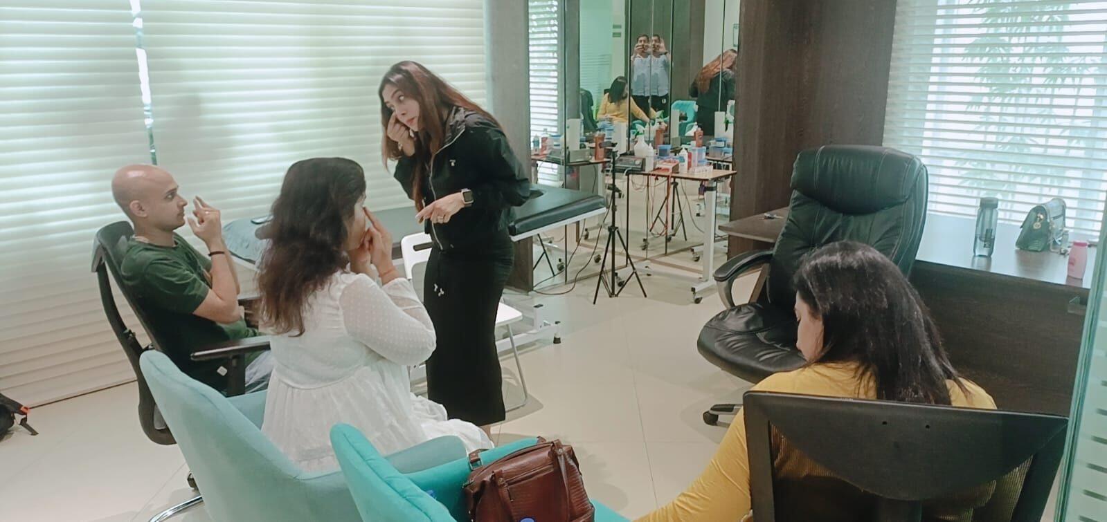 Vibha Jain standing and explaining an approach to three seated clients in a consulting room.